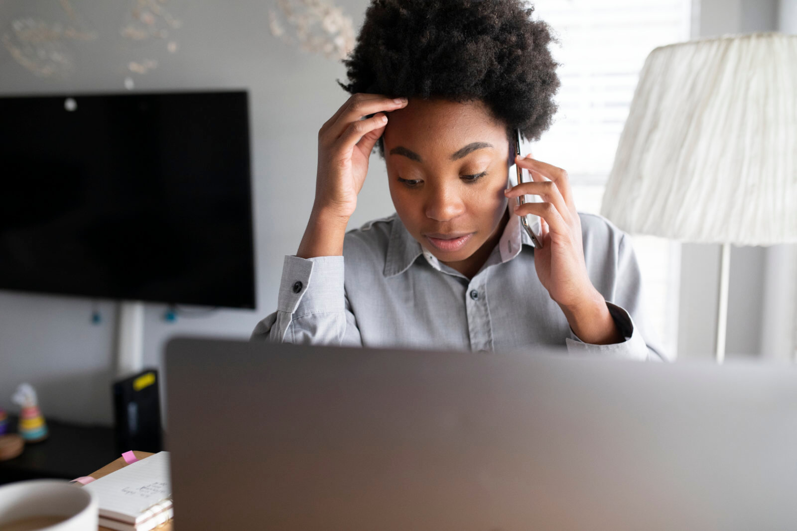 person on a phone in front of a computer